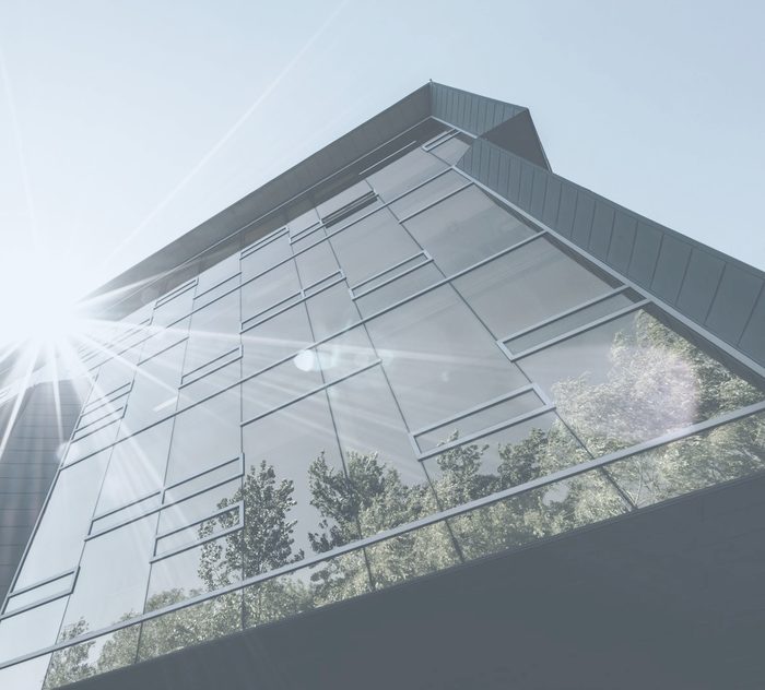 Façade vitrée d’un immeuble de bureaux baignée de soleil
