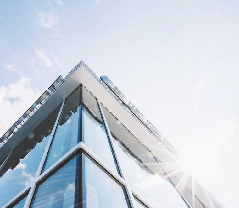 Immeuble de bureaux aux façades de verre baigné de soleil